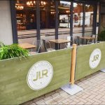 JLR Live Lounge Rustic Cafe Barrier Posts and Wooden Framed Cafe Panels, Painted Green branded with their Logo in White, Powder Coated Cafe Barrier Posts, Custom Cafe Panels, Bespoke Cafe Panels
