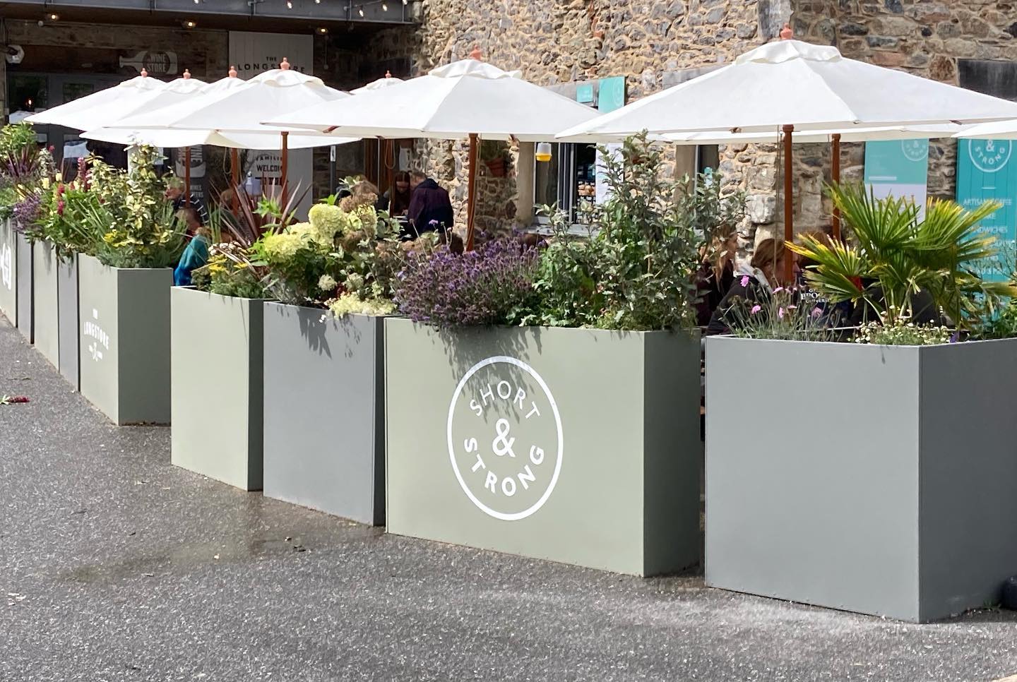 Longshore Restaurant in Cornwall Forjado Metal Planters Powder Coated in Green & Blue with their logos to all