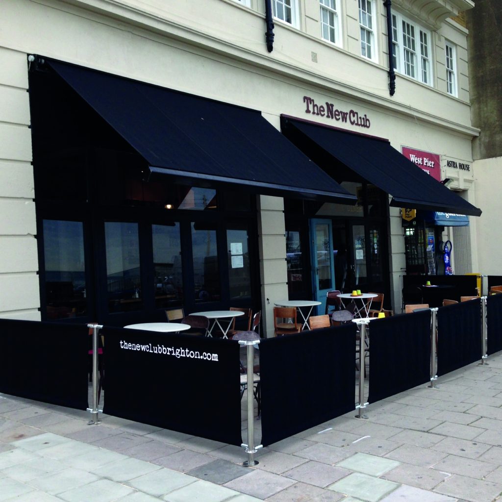 Shade & Shelter, Brighton New Club Commercial Awnings, Floor Socket Advance Cafe Barrier Posts and Black Canvas Cafe Banners, printed café banners, bespoke café banners, handmade café banners, custom café banners, café screens, fabric café banners, heavy duty cafe barriers, outdoor cafe barriers, custom banners, commercial cafe barriers, branded banners