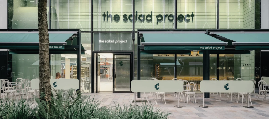 Anterior Cafe Panel outside The Salad Project, Victoria London, Anterior Panel, Aluminium Cafe Panels, Restaurant Cafe Screens, Cafe Screening, Queue Barriers, Alfresco Dining, Commercial Cafe Panels, Bespoke Cafe Panels, Hospitality Cafe Barrier Panels